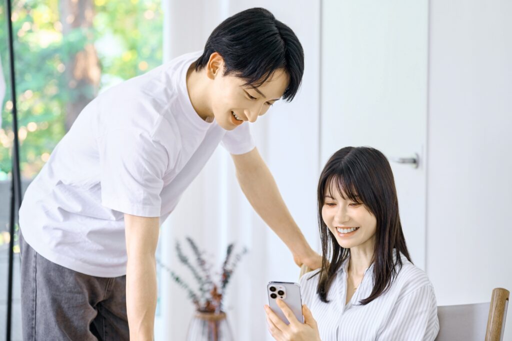 リビングでスマホを見るカップル